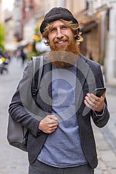 Young man use smartphone typing text messages browsing internet finishing work looking at camera