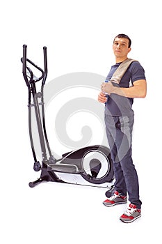 Young man uses elliptical cross trainer.