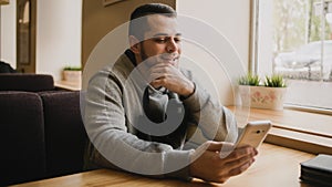 Young man uses the phone in a cafe.