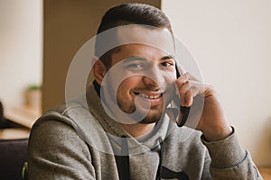 Young man uses the phone in a cafe.