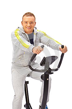 Young man uses stationary bicycle trainer.
