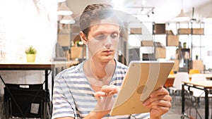 Young Man Using Applications on Tablet Computer, Portrait