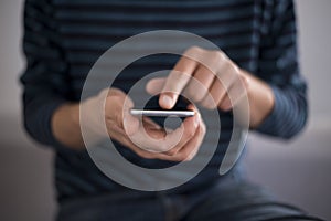 Young man using touchscreen smartphone. Concept for using technology, shopping online, using mobile apps, texting, phone addiction photo