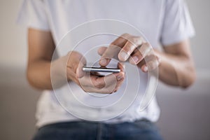 Young man using touchscreen smartphone. Concept for using technology, shopping online, using mobile apps, texting, phone addiction photo