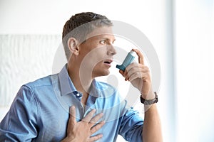 Young man using asthma inhaler