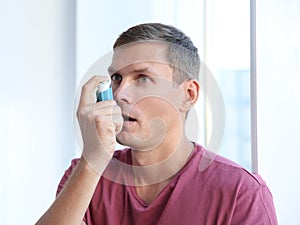 Young man using asthma inhaler