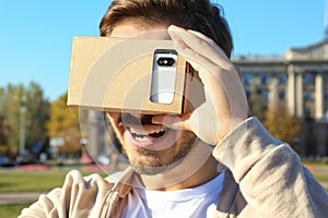 Young man using cardboard virtual reality headset