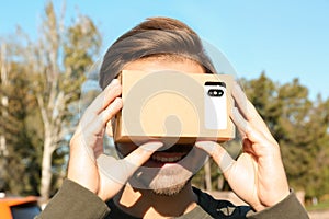 Young man using cardboard virtual reality headset