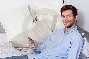 Young man using cellphone on couch