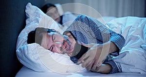 Young Man Using Cellphone While Her Wife Sitting On Bed