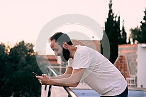 Young man using a chat app in his forest house