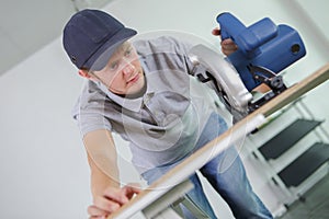 Young man using circular saw on work bench