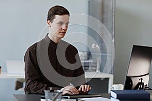 Young man using computer in clean office workplace