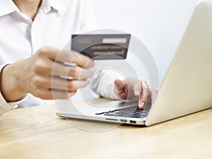 Young man using credit card while shopping online