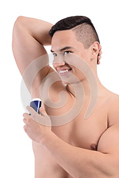 Young man using deodorant on white background