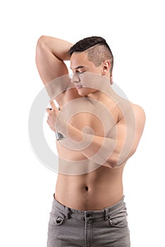 Young man using deodorant on white background