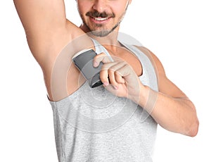 Young man using deodorant on white background