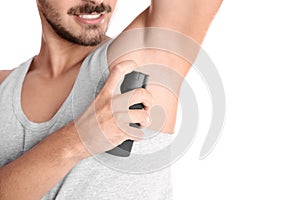 Young man using deodorant on white background