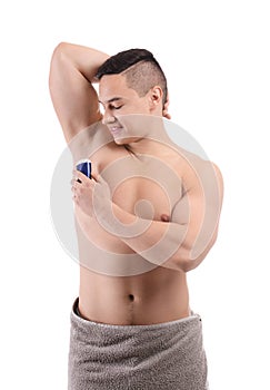 Young man using deodorant on white background