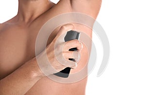 Young man using deodorant on white background,