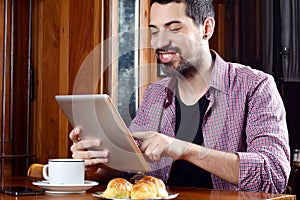 Young man using digital tablet at a cafe.