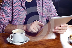 Young man using digital tablet at a cafe.