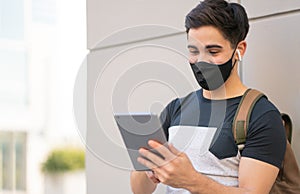 Young man using digital tablet outdoors.