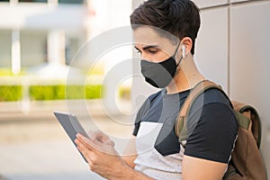 Young man using digital tablet outdoors.