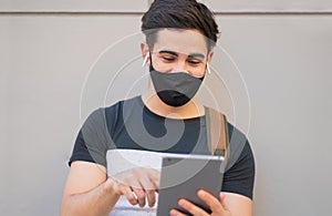 Young man using digital tablet outdoors.