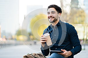 Young man using digital tablet outdoors.