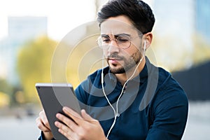 Young man using digital tablet outdoors.