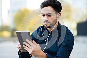 Young man using digital tablet outdoors.