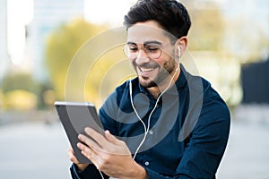 Young man using digital tablet outdoors.