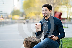 Young man using digital tablet outdoors.