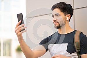 Young man using face id for unlock mobile phone outdoors.