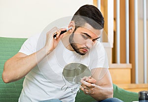 Young man using hair trimmer