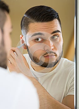 Young man using hair trimmer