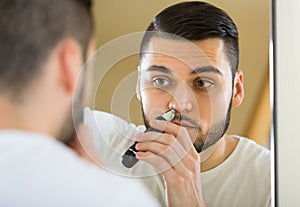 Young man using hair trimmer