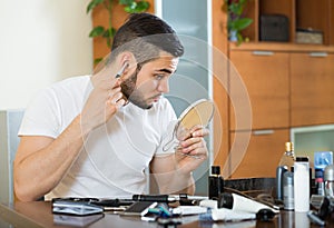 Young man using hair trimmer