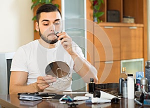 Young man using hair trimmer