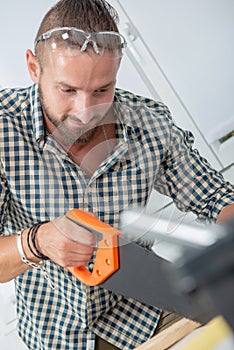 Young man using a handsaw