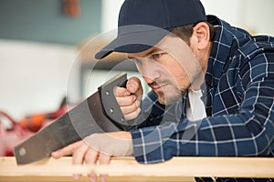 Young man using handsaw