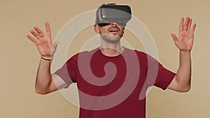 Young man using headset helmet app to play simulation drawing game watching virtual reality 3D video