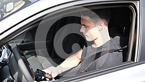 Young Man Using his Cell Phone Driving Car