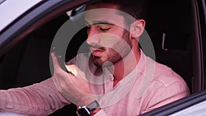Young Man Using his Cell Phone Driving a Car