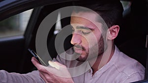 Young Man Using his Cell Phone Driving a Car