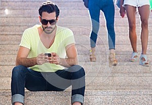 Young man using his mobile phone in the street.