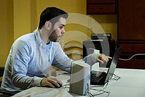 Young man using his mobile, tablet, laptop and headphones