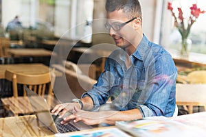 Young man using laptop at cafe