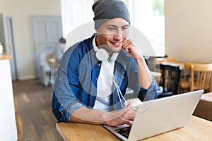 Young man using laptop at cafe